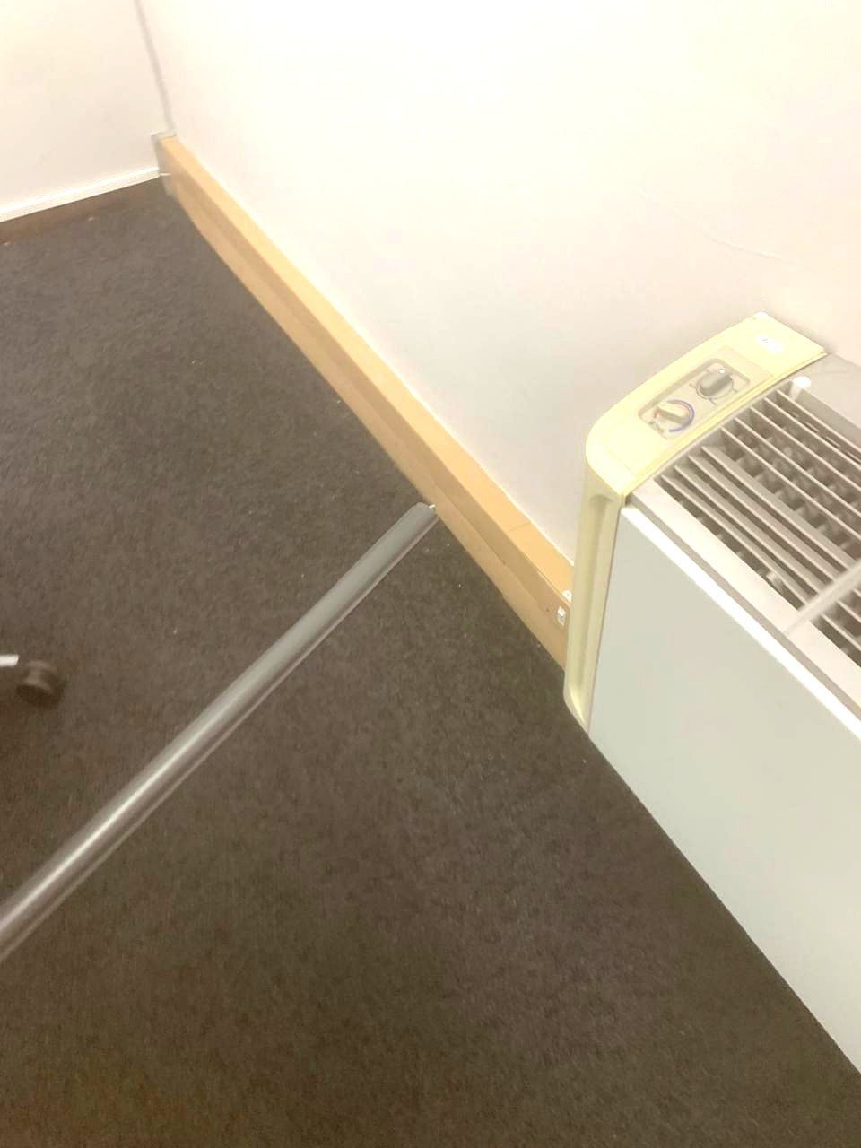 Floor trunking running along a skirting board past an air-conditioning unit