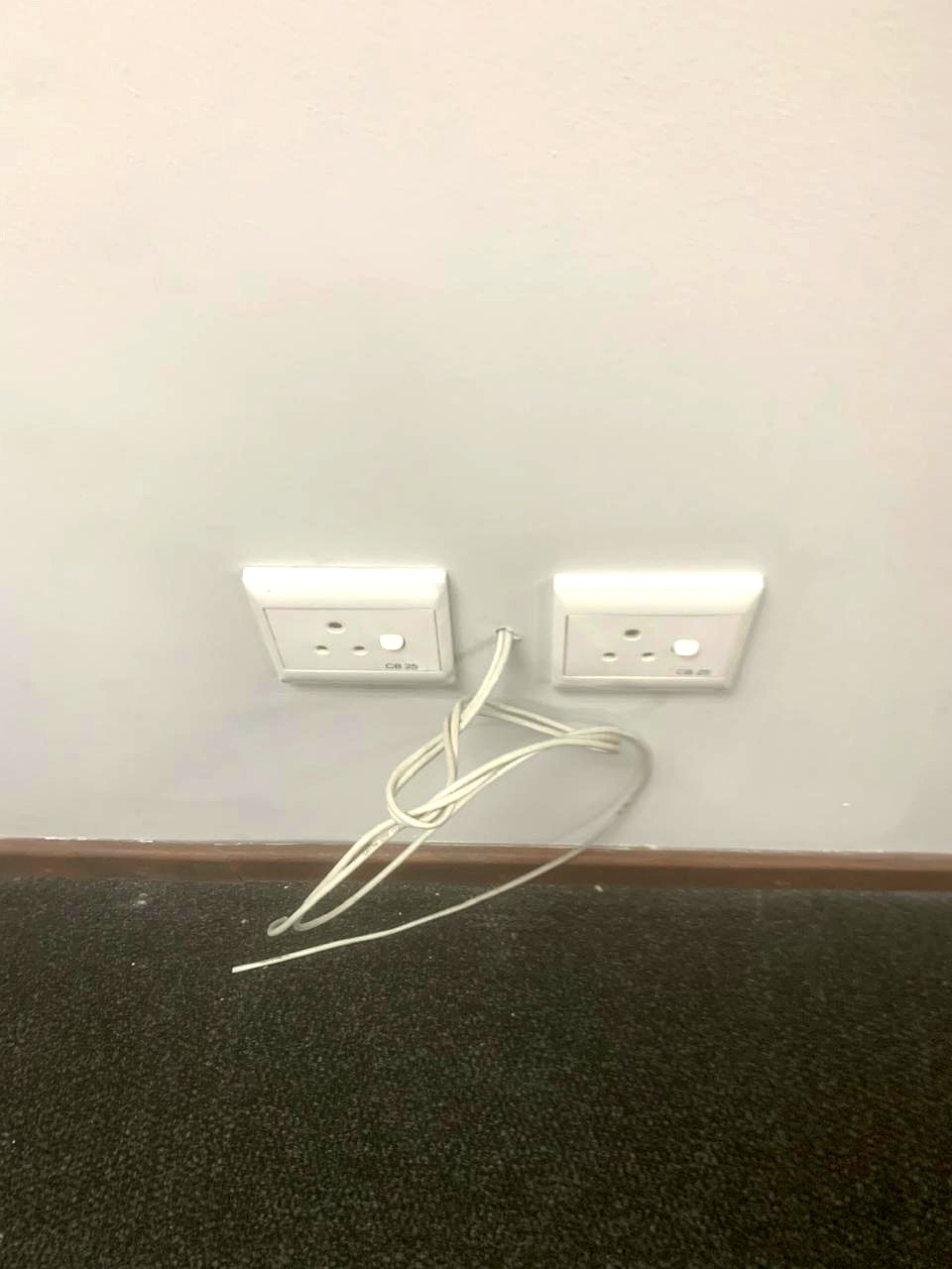 Two wall power sockets with network cable routed neatly to skirting level