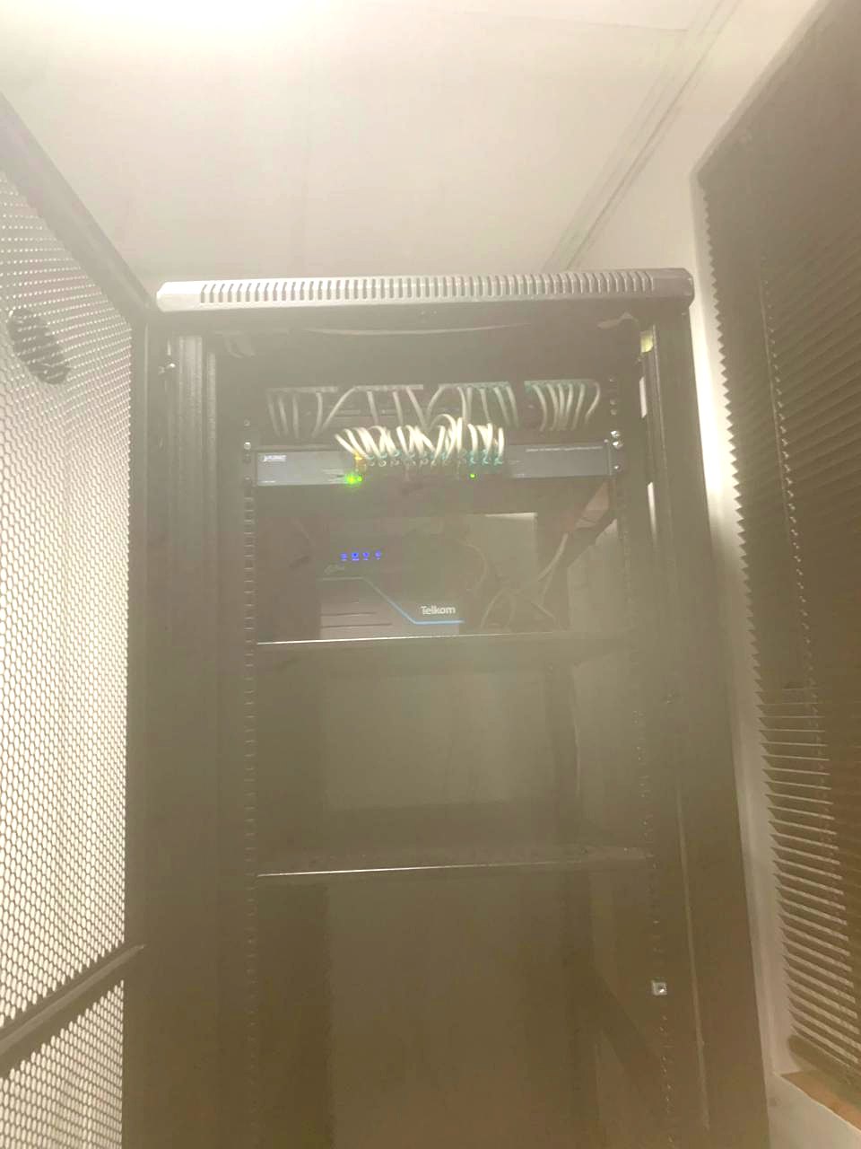 Close-up of a live patch panel and switch with neatly looped patch leads