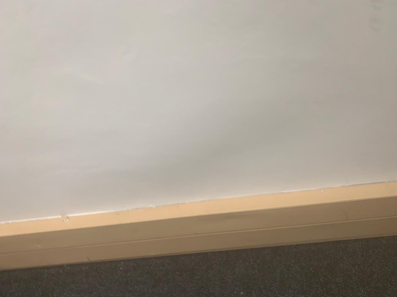 Bare wall and skirting section assessed for new trunking and cable routes