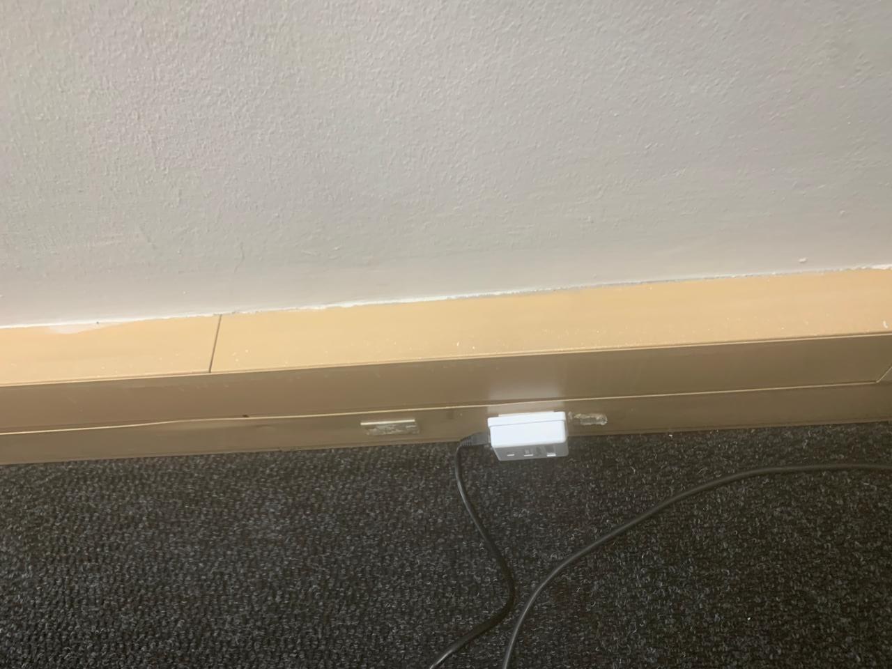 Single floor-level data outlet with an unmanaged cable run across the office