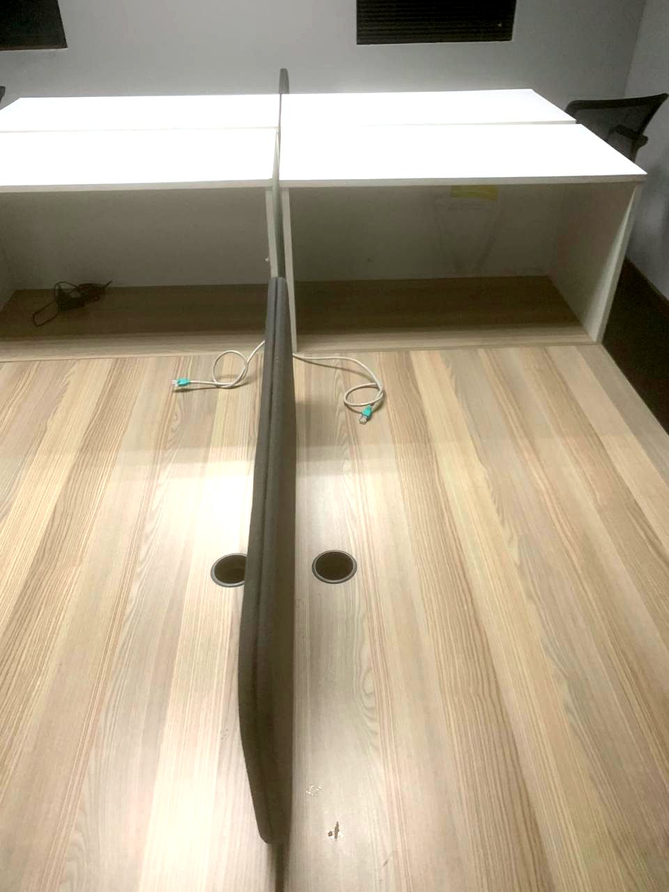Two workstation desks with network patch leads fed through desk cable grommets