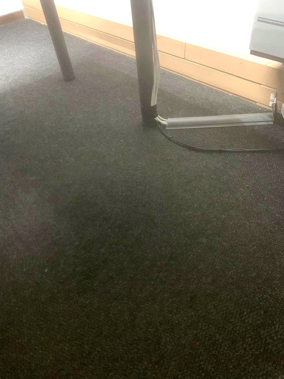 Desk legs with cabling contained in floor ducting along the skirting