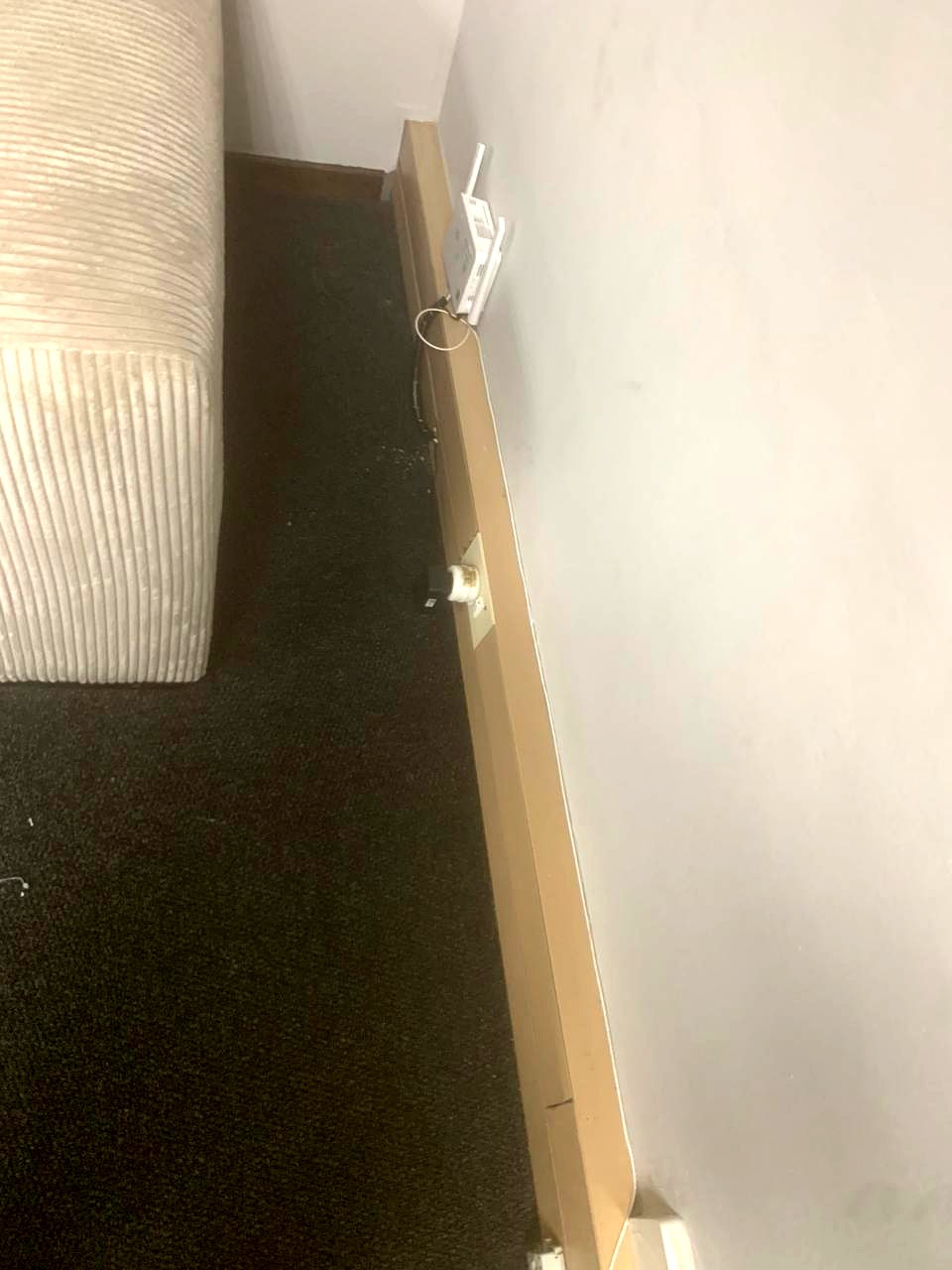 Wall-mounted wireless access point above a data outlet on the skirting board