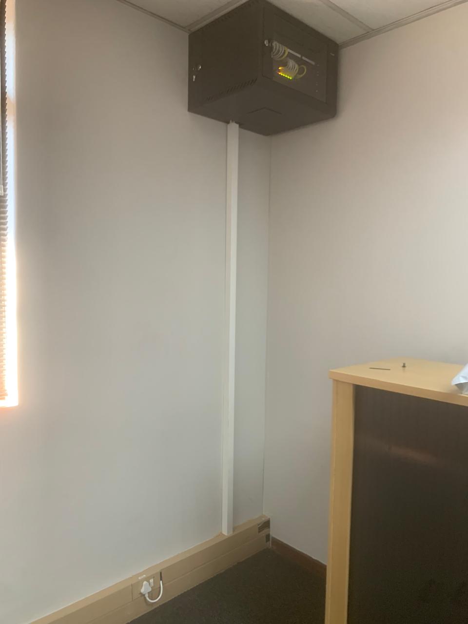 Wall-mounted network cabinet with patched switch and trunking run to floor level